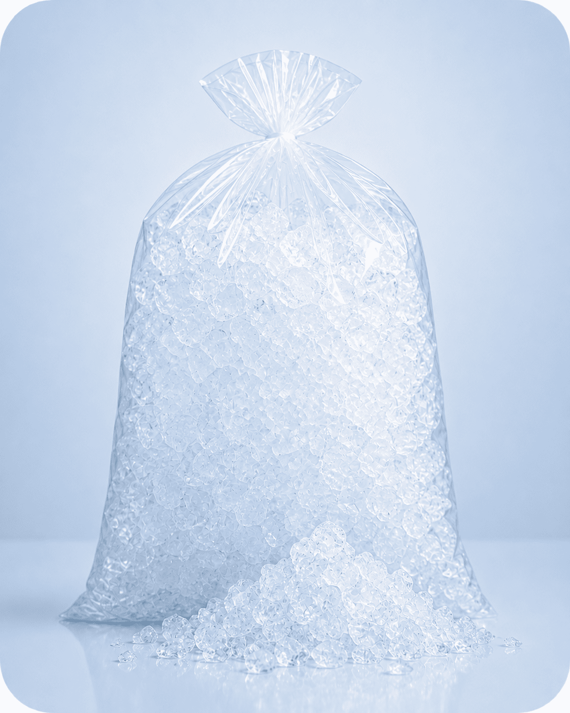 Clear plastic bag filled with crushed ice with some spilled in front on a reflective surface.